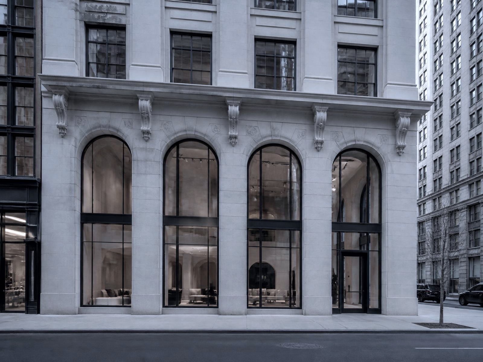 Limestone showroom building with tall arched steel-framed glazing in Midtown Manhattan